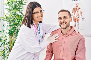 Wall Mural - Man and woman doctor and patient hugging each other at clinic