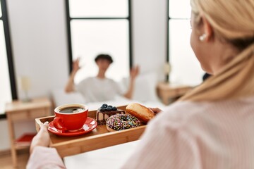 Poster - Woman surprising her boyfriend with breakfast on the bed at home.