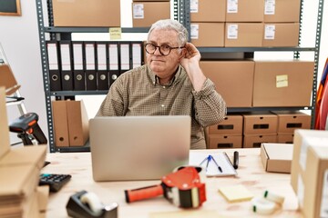 Sticker - Senior caucasian man working at small business ecommerce with laptop smiling with hand over ear listening an hearing to rumor or gossip. deafness concept.