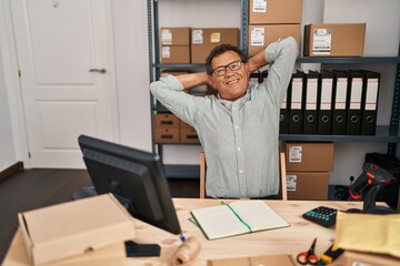 Middle age man ecommerce business worker relaxed with hands on head at office