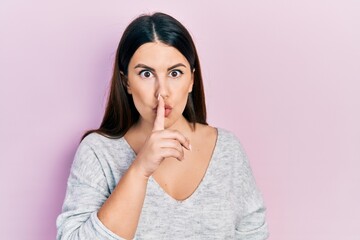 Canvas Print - Young hispanic woman wearing casual clothes asking to be quiet with finger on lips. silence and secret concept.