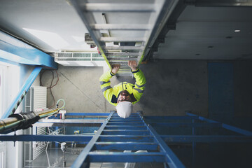 Top view of engineer in industrial factory climbing up the ladder.