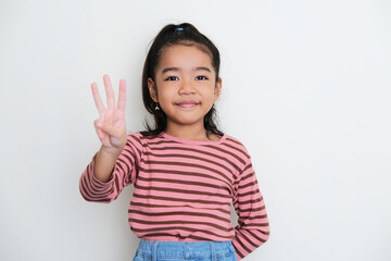 Wall Mural - Asian little girl smiling to the camera and give three fingers sign