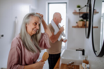 Wall Mural - Senior couple in bathroom, brushing teeth and washing, morning routine concept.