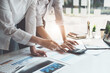© Jirapong - financial, Planning, Marketing and Accounting, Asian woman Economist pointing to investment documents with partners on profit taking to compete with other companies
