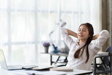 Wall Mural - Portrait of beautiful asian woman relaxing in office, Happy relaxed woman having break and resting in office.