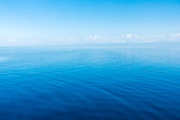 Wall Mural - Clear water texture in blue and orange. Background of the ocean and the sea backlit by the sun. Natural water