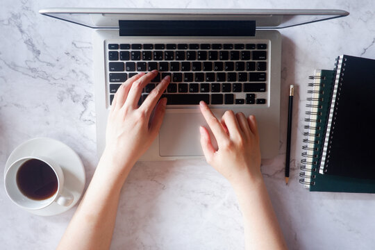 Cropped shot view of business woman’s hands typing the labtop with blank copy space screen for your information content or text message.
