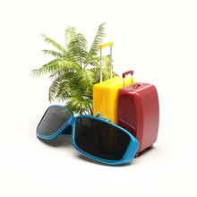 Composition Of Suitcases With Sun Glasses And Palm on White Background