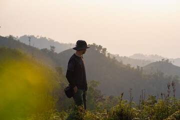 Canvas Print - silhouette hiker man relax on mountain with sunset background