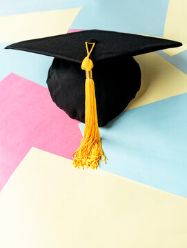 Black graduation cap or hat with yellow tassel on colorful pastel background education Academic cap or Mortarboard