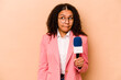 Young African American TV presenter woman isolated on beige background confused, feels doubtful and unsure.