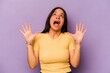 © Asier - Young hispanic woman isolated on purple background screaming to the sky, looking up, frustrated.