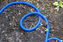 Blue Plastic Hose For Irrigation On The Ground