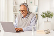 © Ljupco Smokovski - Mature man with headphones sitting in front of a laptop computer at home