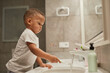 © Seventyfour - Side view portrait of African American toddler boy brushing teeth in bathroom, copy space