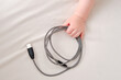 Baby toddler boy holds a usb cable in his hand to charge his phone. Child with a wire in his hands, close-up
