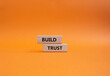 Build trust symbol. Wooden blocks with words Build trust. Beautiful orange background. Business and Build trust concept. Copy space.