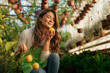 © DusanJelicic - A woman in her 30s enjoys picking and smelling the beautiful scent of organic lemon grown in her greenhouse.