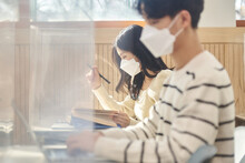 전염병 상황에 마스크 쓰고 강의실에서 공부 또는 수업을 듣고 있는 아시아 대한민국 젊은 대학생 남자 여자 모델