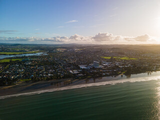 Wall Mural - Aerial view of Orewa Beach in New Zealand through golden hour