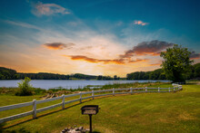 A Gorgeous Summer Landscape At Lake Acworth With Rippling Blue Lake Water Surrounded By Lush Green Grass And Trees With A White Wooden Fence And Powerful Clouds At Sunset Y At Cauble Park In Acworth
