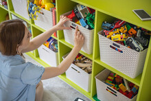 Woman Hands Applying Sticker With Name Title Of Children Toys For Comfortable Sorting And Storage