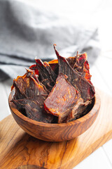 Canvas Print - Beef jerky meat. Dried sliced meat in wooden bowl.