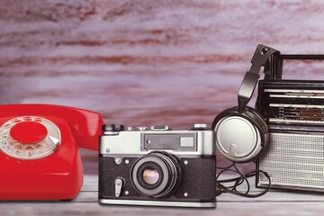 Sticker - Old retro tape recorder and telephone on a wooden table. Vintage filtered old style.