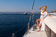 © Anatoly Repin - Beautiful young blond woman in a dress standing on yacht stern on the sea or ocean
