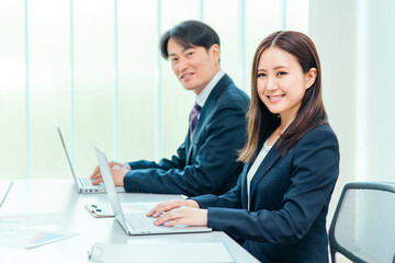 Poster - 会議室にいるスーツ姿の男女（カメラ目線・笑顔）
