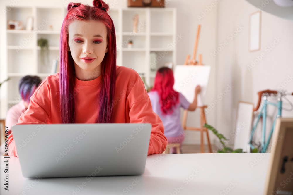 Beautiful woman with bright hair using laptop at home