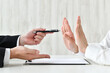 © takasu - 契約を迫るビジネスマンとそれを拒む人物の手元