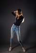 © qunica.com - Attractive female model in denim jeans posing isolated on grey background.