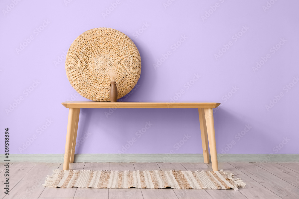Stylish decor on wooden table near violet wall in room interior