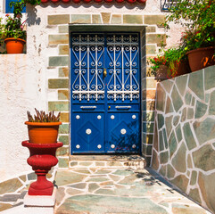 Wall Mural - Charming typical floral streets of Greek islands with whitewashed houses and blue doors