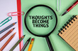 Thoughts become things. Text and magnifying glass on a green paper background