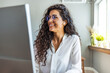 © Dragana Gordic - Happy Worker. Portrait of smiling girl in headphones using PC, sitting at office and listening to music, copyspace. Cheerful woman wearing wireless earphones and smiling
