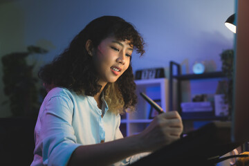 Fototapete - Young female designer working on the table in home studio and hand using digital pen on monitor screen with editor retouching photos.