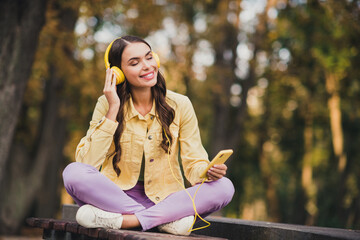 Canvas Print - Portrait of beautiful trendy cheerful dreamy girl sitting on bench listening soul melody hit jazz enjoying resting outdoors