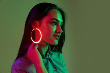 Young beautiful girl with fashion neon accessories, jewelry isolated over light background. Concept of beauty, digital fashion style, creativity