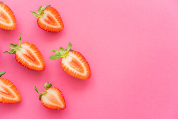 Canvas Print - Flat lay of cut fresh strawberries on pink background.