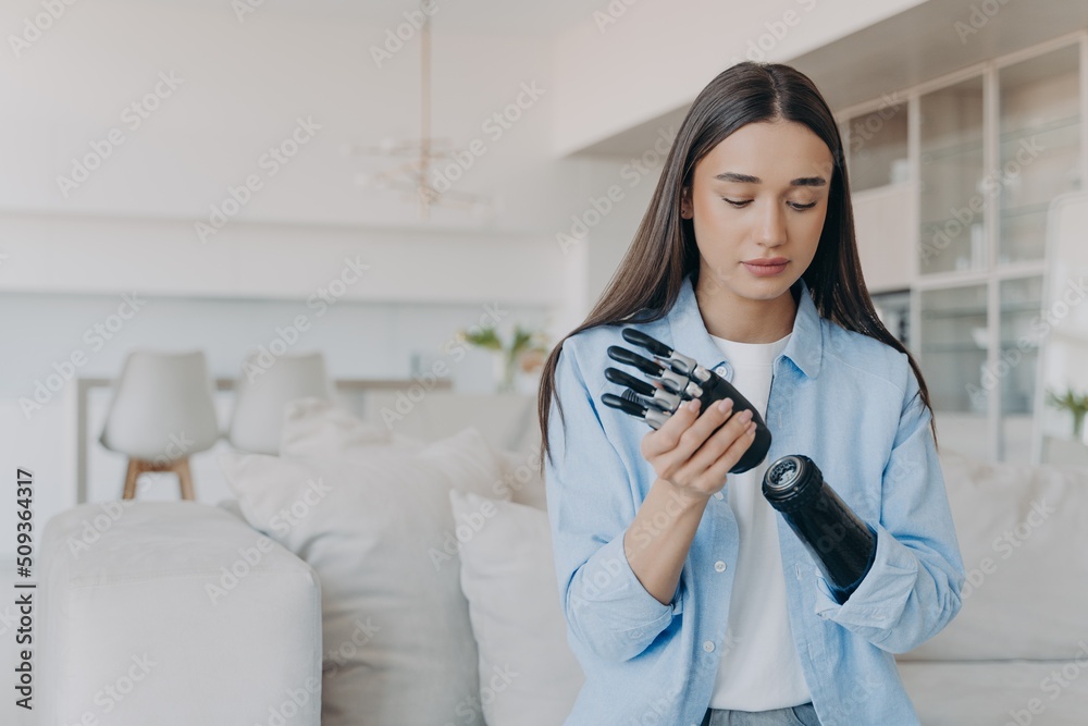 Hand Function Disable Disabled young woman getting used to new bionic prosthesis. Girl ...