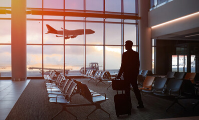 Poster - Businessman with suitcase and bag in waiting area at airport