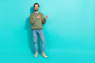 Wall Mural - Full length photo of young man indicate fingers empty space promo recommend select isolated over turquoise color background