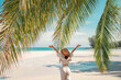 © oatawa - Summer beach vacation concept, Happy woman with hat relaxing at the seaside and looking away, in the summer against a backdrop of palm trees and sea beach.