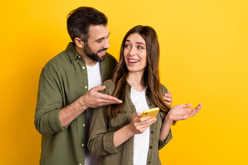 Poster - Portrait of attractive cheerful couple using device talking discussing app 5g isolated over bright yellow color background