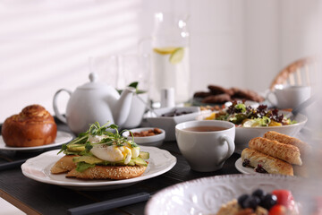 Delicious sandwiches with eggs and avocado served on buffet table for brunch