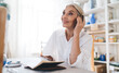 © BullRun - Businesswoman working at table at home art studio