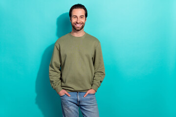 Canvas Print - Photo of young cheerful man good mood hands in pocket wear casual clothes isolated over turquoise color background